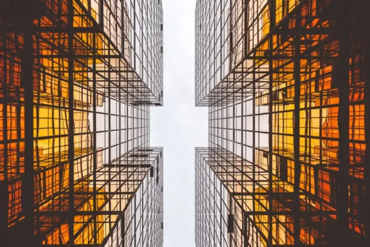 woman looking at her phone and ecommerce store on laptop
